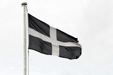 Cornish independence flag flying against a white sky
