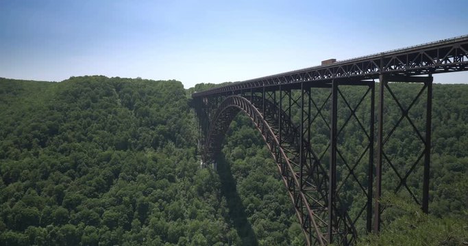 A daytime establishing shot of the New River Gorge Bridge spanning the New River in West Virginia.  	