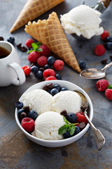 Vanilla ice cream scoops in a bowl with fresh berries