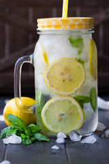 Sassy water. Lemonade. Refreshing cold drink with mint, cucumber, lemons. Sliced lemons with mint in mason jar  filled with ice and water. Mojito. Every day drink.