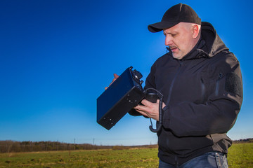 The man is setting up a radio link. Portable radio station. Talk on the radio.