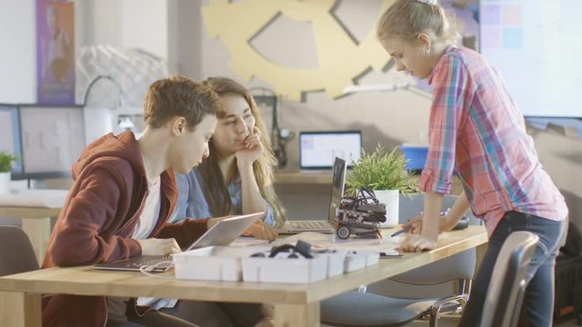 Boy and Two Girls Working on a Schools Science Class Project. They Draw, Use Laptop and Build Robotics. Shot on RED EPIC-W 8K Helium Cinema Camera.