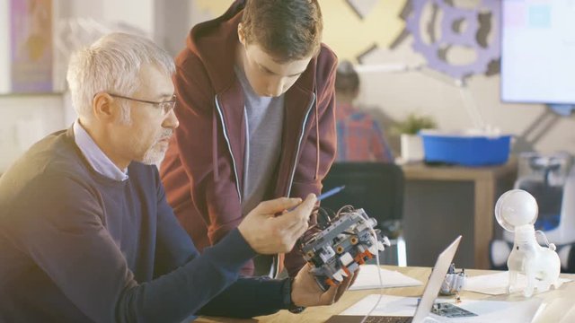 In Computer Science Class Teacher Examines programed Robot Engineered by His Student for School Project.Shot on RED EPIC-W 8K Helium Cinema Camera.
