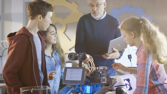 Teacher and His Pupils Work on a Programable Robot with LED Illumination for School Science Class Project.Shot on RED EPIC-W 8K Helium Cinema Camera.