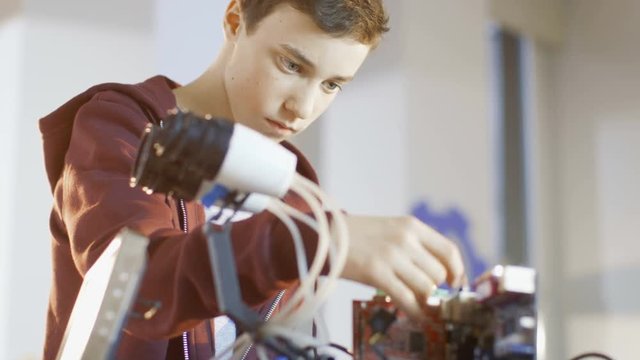 Boy Works on a Fully Functional Programable Robot with Bright LED Lights for His School Robotics Club Project. Shot on RED EPIC-W 8K Helium Cinema Camera.
