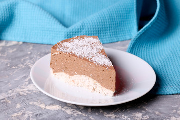 Three chocolate mousse cake with cocos slice on a small plate
