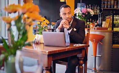 Thoughtful male in a cafe using laptop.