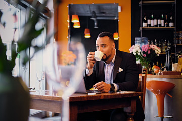 A man drinks coffee in a restaurant.