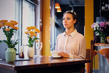 Female drinks coffee in a cafe.