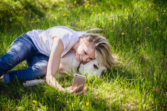 The girl makes selfie with a labrador