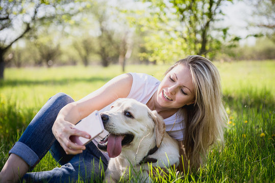 The girl makes selfie with a labrador