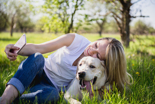 The girl makes selfie with a labrador