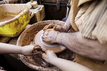 Person working clay with hands, traditional craft, potter