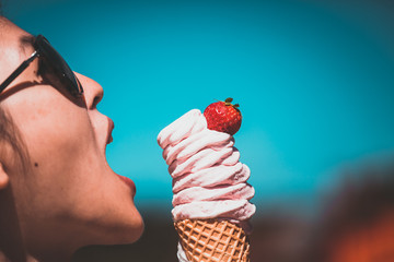 Girl taste strawberry flavor ice-cream on sunny day