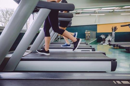 Close up of people legs running over treadmill in a training session on fitness center