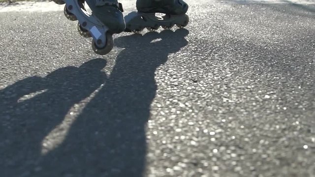 Close-up of a girl at sunset on roller skates. Slow motion