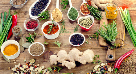 Spices and fresh herbs on rustic  wooden background.
