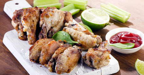 Chicken wings with celery on a wooden cutting board
