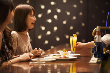 Women are drinking cocktails at the bar