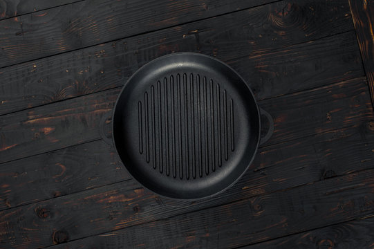 Vintage empty grill pan on dark wooden table close up
