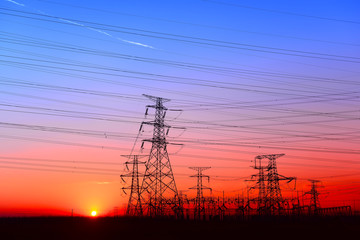 Fototapeta premium Wysokie wieże piezoelektryczne w zachodzącym słońcu