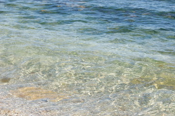Fototapeta na wymiar Sand on the beach, waves with white foam