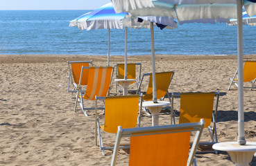 sun umbrellas and yellow beach cots on the sand of the luxurious tourist resort