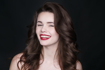 Fototapeta premium I know what you mean. Studio portrait of a beautiful brunette curly haired model laughing and looking to the camera.