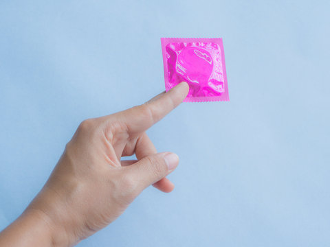 Hand holding condom and sexy legs,selective focus, save sex image.