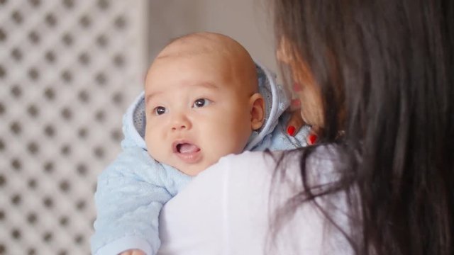 Happy asian mother holding child baby