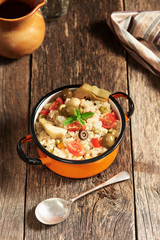 Quinoa salad in a small pot on a wooden table