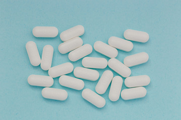 white tablets  pills macro on blue background, top view