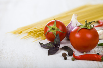 Raw pasta and spices in wooden table.