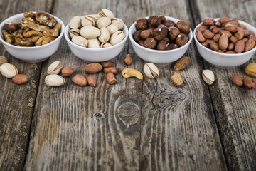 Nuts in a plate on a  wooden table.