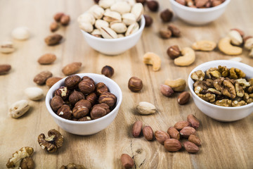 Nuts in a plate on a  wooden table.
