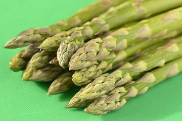 Asparagus spears on green chopping board