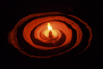 Lighting from oil lamp with helical shaped lantern base, Arts from a pile of sand.