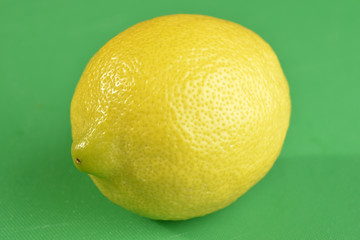 Lemon on green chopping board