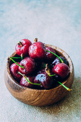 Fresh Ripe cherries in wooden bowl on table background. Summer berries. Healthy food concept. Copy space, top view