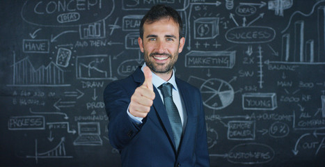 Portrait of a business man, a marketing teacher, draws a graph of success on a black board, on a black background. The concept: career growth, growth chart, successful man, marketing, ideas, finance.	