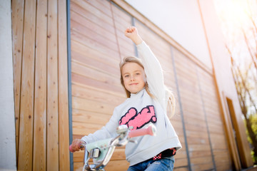 Girl on bicycle near wall