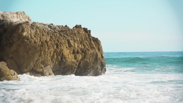 Waves crash on the rocks. Beautiful shot and georgous highleted waves. Perfect clear blue clean water. Rocks cause large sprays of water when the waves slam through them. Visitors and tourists enjoy.