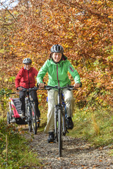 Plakat gutgelaunte Familie beim Radfahren im Herbst