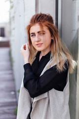 One girl pose to camera near the wall with sunlight