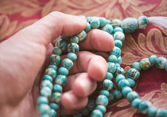 Man holding beads for pray in a temple
