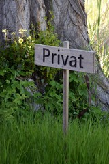 Hinweis auf Privat, Holzbrett mit Beschriftung Privat im Garten stehend, 