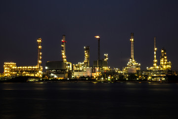 Obraz na płótnie Canvas View of oil refinery industry plant in the night and river.