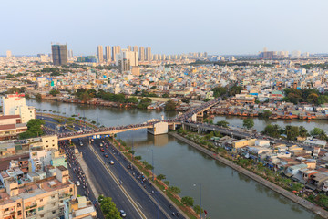 Fototapeta na wymiar Ho Chi Minh city scape in Vo Van Kiet boulevard, canal, buildings and traffic around Cau Chu Y bridge, district 8