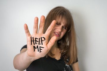 Sad woman is showing hand with message help me