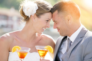 Bride and groom cheering with cocktails